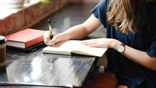 woman in a cafe writing in journal